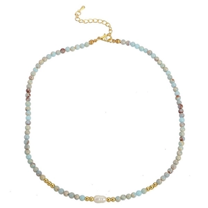 Detail of beaded necklace with blue stones, a center white pearl, and gold lobster clasp