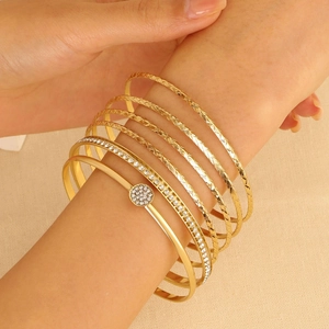 7-piece set of gold vintage alloy bracelets with rhinestones on a woman's wrist