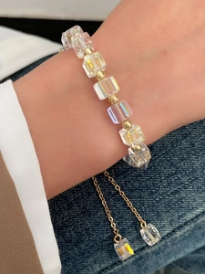 Detailed view of beaded tassel bracelet with AB crystal cubes and gold adjustable chain
