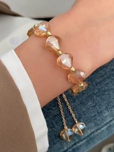 Close-up of adjustable golden bracelet with amber crystal faceted beads on wrist