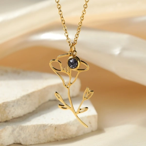 Detail of gold floral necklace featuring a purple zircon and intricate hollow craftsmanship