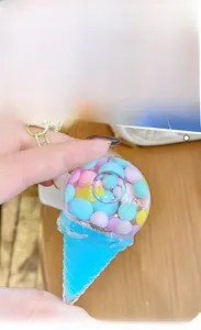Close-up of ice cream keychain with colorful candy beads inside a transparent sphere