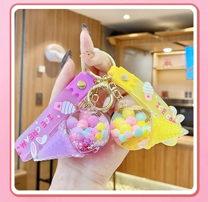 Detailed macro of creative purple and yellow ice cream keychain with colorful quicksand