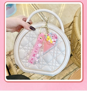 Detail of ice cream keychain with pink silicone strap attached to a luxury quilted bag