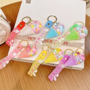 Colorful ice cream liquid quicksand keychains with silicone straps on a desk