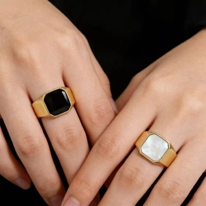 Elegant minimalist golden ring with black onyx and white shell inlays on model hands