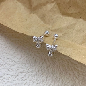 Macro shot of S925 sterling silver bow stud earrings with S925 hallmark on polished post