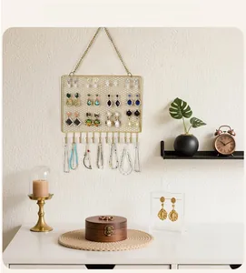 Close-up of golden mesh wall jewelry organizer with hooks for earrings and necklaces