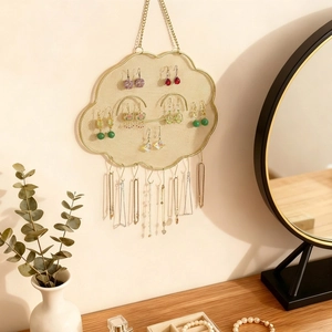 Cloud-shaped gold metal jewelry organizer with mesh grid and hooks for wall display