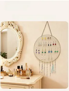 Macro detail of round gold metal mesh jewelry organizer with hooks for earrings and necklaces