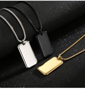 Detailed close-up of rectangular dog tag necklaces in silver, gold, and black metal tones
