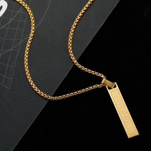 Macro shot of gold stainless steel rectangular pendant with engraved Roman numerals