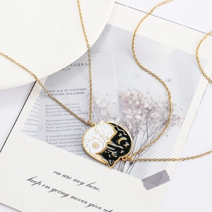 Detailed close-up of cat-themed yin yang necklaces on golden chains with celestial motifs