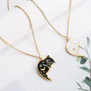 Macro detail of cute black and white cat pendants with sun and moon enamel patterns