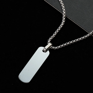 Macro shot of polished silver rectangle pendant with industrial square link steel chain