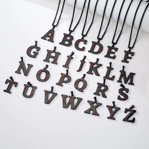 Macro view of stainless steel baseball letter necklaces with red stitch details