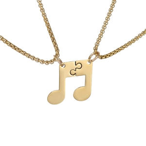 Gros plan sur l'ensemble pendentif note de musique dorée imbriquée avec chaîne de boîte