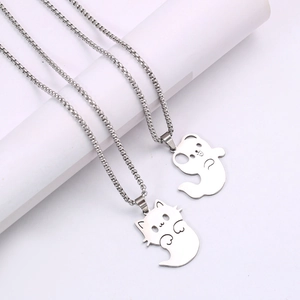 Colliers avec pendentifs chat et chien mignons en acier inoxydable sur fond blanc épuré