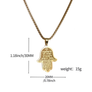 Détail du pendentif Hamsa doré avec des écritures hébraïques et gravures de ville