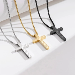 Detailed view of stainless steel cross pendants in silver, gold, and black finishes