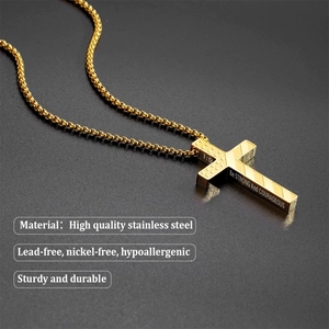 Macro view of gold stainless steel cross necklace with Be Strong And Courageous engraving