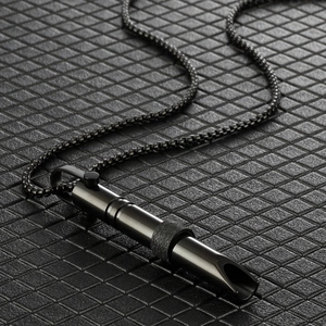 Detalle macro del collar de respiración de acero inoxidable negro mate con anillo grabado