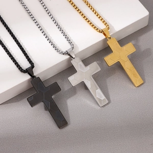 Detalle de colgantes de cruz en negro plata y oro con patrones geométricos texturizados