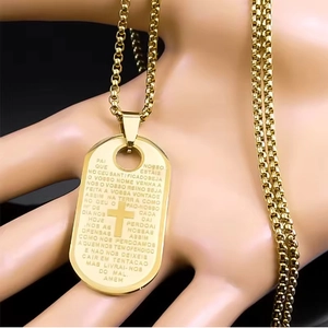 Macro view of gold stainless steel cross pendant with Portuguese Lord's Prayer engraving