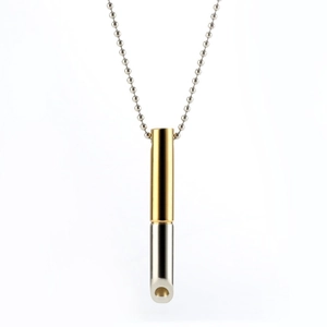 Macro detail of dual-tone gold and silver mindfulness breathing whistle necklace pendant