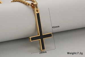 Detailed macro view of an inverted cross pendant with black enamel inlay and box chain