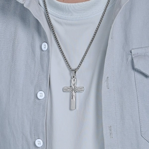 Men's minimalist stainless steel cross necklace with starburst texture on denim shirt