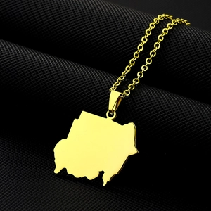 Gros plan du collier pendentif carte du Soudan doré sur fond de texture noire mate