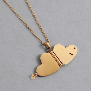 Detail of golden heart-shaped locket necklace with hinged design and cutout texture