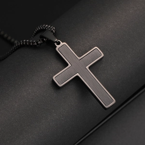 Detalle de colgante de cruz de acero inoxidable cepillado negro con bordes definidos y cadena