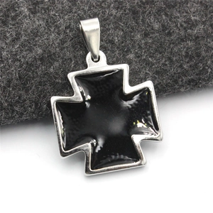 Dettaglio macro del ciondolo a croce in acciaio inossidabile con inserto in smalto nero lucido