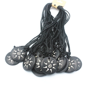 Ethnic black round bone necklace with white sun swirl pattern on black braided rope