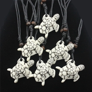 Detail showing resin sea turtle pendants with ethnic black tribal patterns and wooden beads