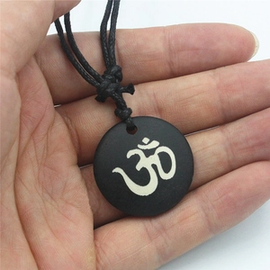 Ciondolo in osso nero fatto a mano con simbolo OM bianco su collana in corda nera