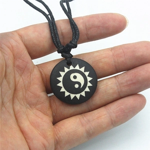 Handcrafted Yin Yang bone necklace with sunburst engraving on round black pendant