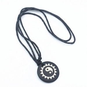 Yin Yang bone pendant necklace with sunburst pattern on adjustable black wax cord