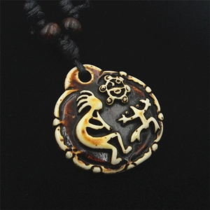 Vista macro di un ciondolo tibetano rotondo con rilievo Kokopelli e cordino nero