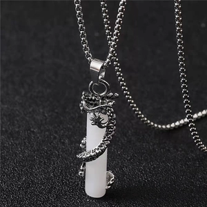Vue détaillée de l'emblème du dragon argenté entourant le pendentif cylindrique blanc