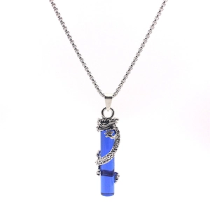 Détail du pendentif dragon argenté sur pilier bleu avec chaîne à mailles carrées