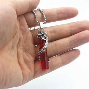 Vue détaillée du pendentif dragon argenté avec pilier en résine rouge translucide