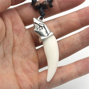 Detailed close-up of shark tooth pendant with silver alloy head and wooden beads decoration