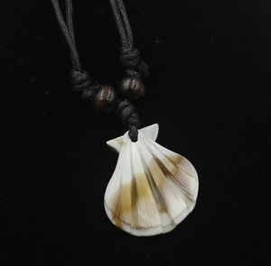 Vue macro détaillée d'un pendentif en coquillage naturel avec des motifs à rayures brunes