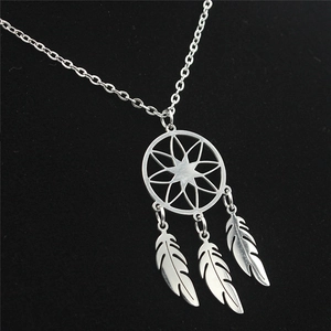 Detailed macro view of dreamcatcher pendant with three delicate silver feather charms