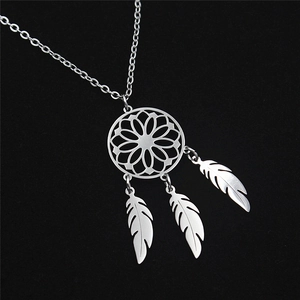 Close-up of silver dreamcatcher necklace pendant with three feathers on a black background