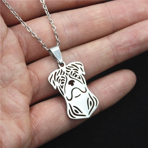 Stainless steel cutout pug dog pendant necklace held in hand for size visualization