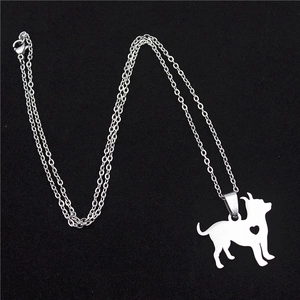 Macro detail of laser-cut stainless steel dog pendant with heart detail and silver chain